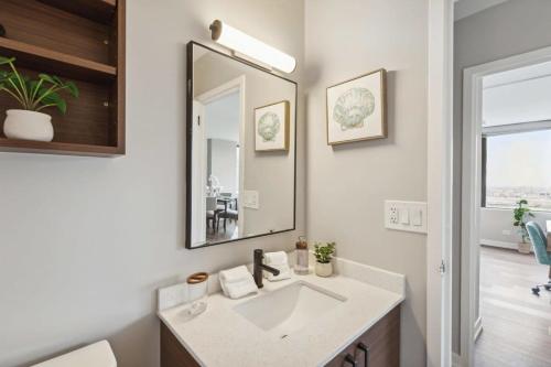 a bathroom with a sink and a mirror at 2BR Vibrant South Loop Apartment in Chicago