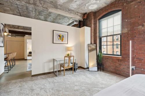 a bedroom with a brick wall and a glass table at 2BR Historic Loft Retreat With Pool & Gym in Pittsburgh