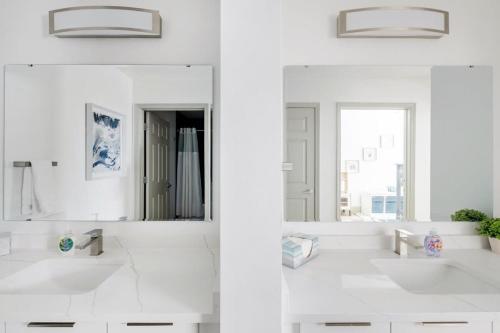 uma casa de banho branca com 2 lavatórios e um espelho em 4B 3BA Premium Family Apartment with Gym em Charlotte