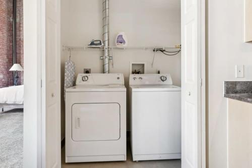 a laundry room with two washing machines and a washer and dryer at 2BR 2BA Lux Historic Loft With Pool in Pittsburgh