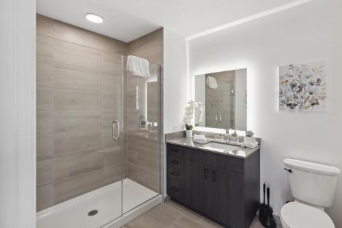 y baño con ducha, aseo y lavamanos. en 2BR Luxury River North Apartment With Wonderful Views, en Chicago