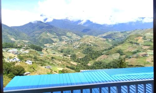 een uitzicht op een bergketen met een blauw dak bij D'TERRACE KUNDASANG in Ranau