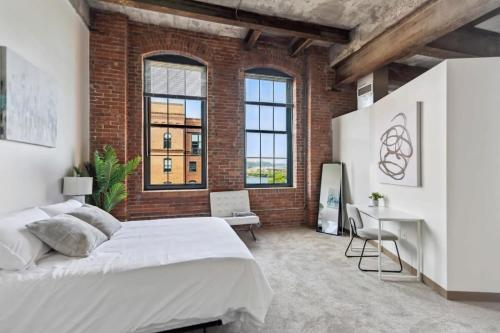 um quarto com uma cama grande e uma parede de tijolos em 2BR Spacious Historic Loft With Pool em Pittsburgh