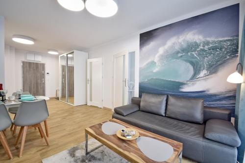 a living room with a couch and a painting on the wall at Piękny Apartament Balticus SeaView by Rent like home in Międzyzdroje