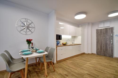 a kitchen and dining room with a table and chairs at Piękny Apartament Balticus SeaView by Rent like home in Międzyzdroje
