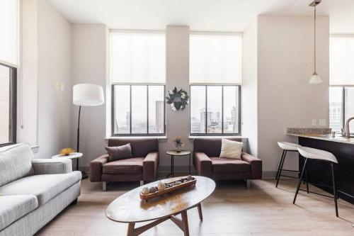 a living room with a couch and a table at 2BR Distinguished Apartment Rooftop Deck & Gym in Baltimore