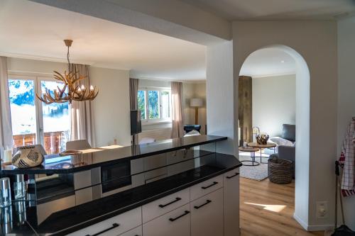 uma cozinha com um balcão preto e uma sala de estar em Höhwald em Arosa