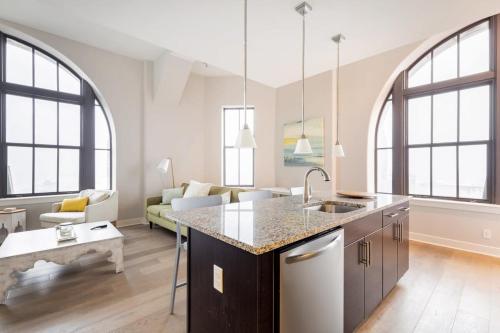 uma cozinha e sala de estar com janelas grandes em 2B 2BA Luxury Downtown Suite Rooftop Deck & Gym em Baltimore