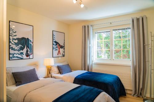 アローザにあるHöhwaldのベッド2台と窓のある寝室