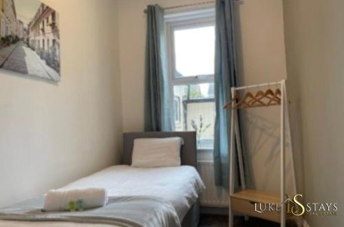 a small bedroom with a bed and a window at Luke Stays - Nicholson Terrace in Killingworth