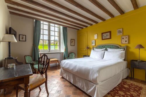 Le Château D'Etoges في إتوج: غرفة نوم بسرير كبير ومكتب وطاولة