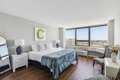 um quarto com uma cama e uma grande janela em 2BR Modern South Loop Suite With Views & Gym em Chicago