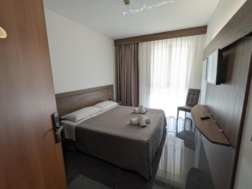 a hotel room with a bed with two teddy bears on it at Hotel Carignano in Lucca