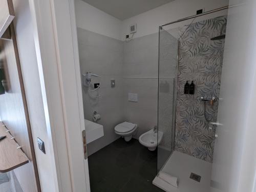 a bathroom with a toilet and a glass shower at Hotel Carignano in Lucca