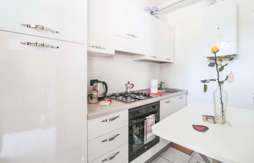 een keuken met witte kasten en een fornuis bij Palma 9 in San Siro