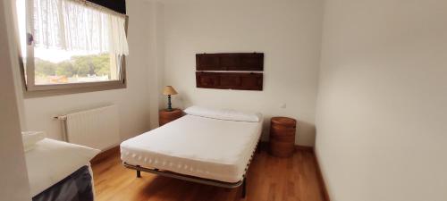 a white room with a bed and a window at Apartamento La Arquera Golf 2 in Llanes