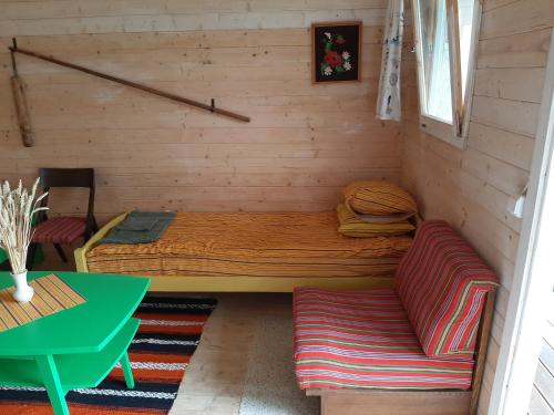 a room with a bed and two couches in it at Kadakasuitsu Loodustalu in Saareküla