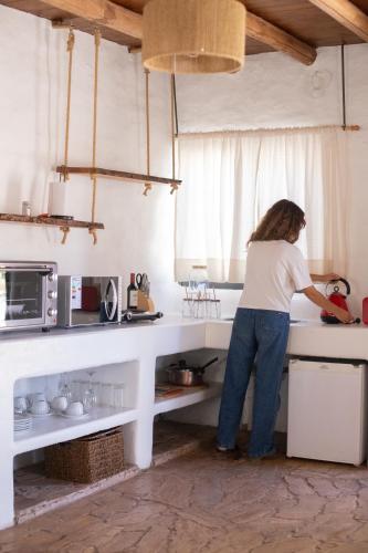 a woman standing at a counter in a kitchen at Cinco Cumbres in Uspallata