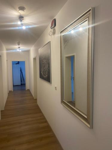 a hallway with a gold framed mirror on a wall at Zimmervermietung Mauersberger in Wendeburg