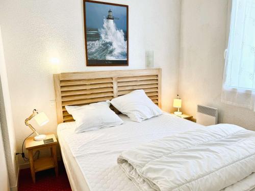 - une chambre avec un lit blanc et une télévision au-dessus dans l'établissement Bel appartement à 100 m de la plage à Fouesnant avec piscine chauffée, pour 4 personnes - FR-1-481-160, à Fouesnant
