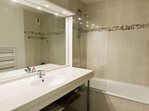 une salle de bain avec un lavabo et une douche avec un miroir dans l'établissement Bel appartement à 100 m de la plage à Fouesnant avec piscine chauffée, pour 4 personnes - FR-1-481-160, à Fouesnant