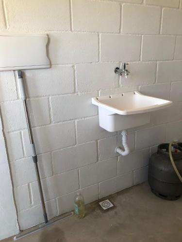 a bathroom with a sink in a white brick wall at Villa Coral azul in Prado