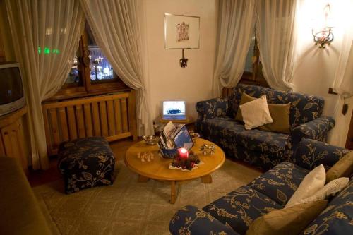 un soggiorno con divano e tavolo di Casa Viola a Cortina dʼAmpezzo