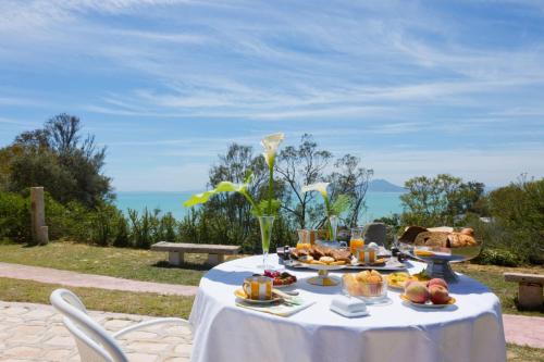 una mesa con comida en ella con el océano en el fondo en Si Brahim studio piscine, Sidi Bou Saïd, en Sidi Bou Saïd