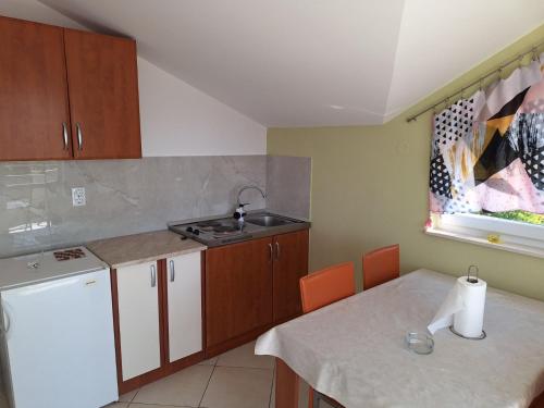 a small kitchen with a sink and a table with a counter at Apartment Bicky in Bijela