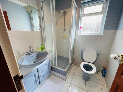 uma casa de banho com um lavatório, um WC e um chuveiro em Luxury Stay em Orpington