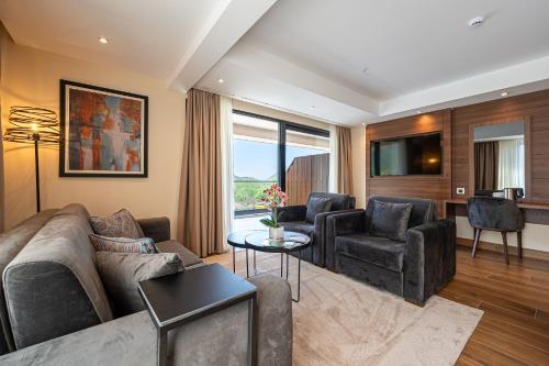 a living room with a couch and two chairs at Hotel De‘Andros Virpazar in Virpazar