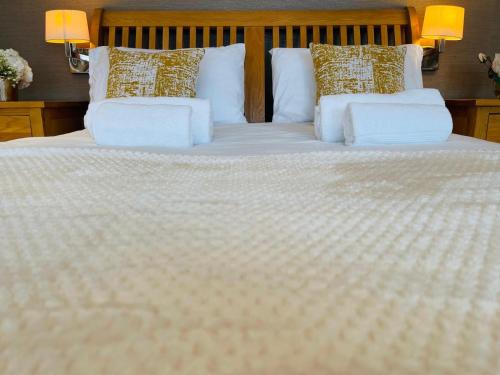 1 cama grande con sábanas y almohadas blancas en Luxury Stay en Orpington