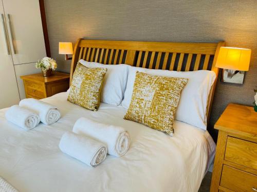 ein weißes Bett mit Handtüchern und Kissen darauf in der Unterkunft Luxury Stay in Orpington