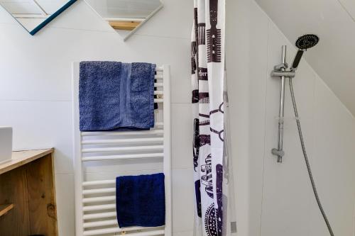 y baño con paredes blancas y toallas azules. en Péniche Destinée, en Burdeos
