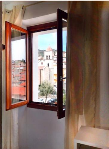a window with a view of a building at La plaza in Ollolai