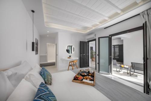 a living room with a white couch and a mirror at Deliades Hotel in Ornos