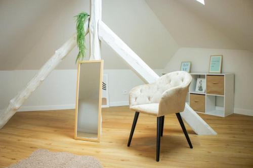 a white chair and a mirror in a room at Le douillet : Duplex élégant en Centre ville in Albertville