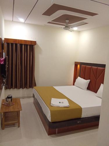 a bedroom with a large bed and a table at Hotel Maruti in Ahmedabad