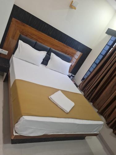 a bedroom with a large bed with a wooden headboard at Hotel Maruti in Ahmedabad