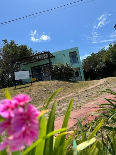 una casa in cima a una collina con un fiore rosa di Hotel Donatella mare boutique a Punta del Este