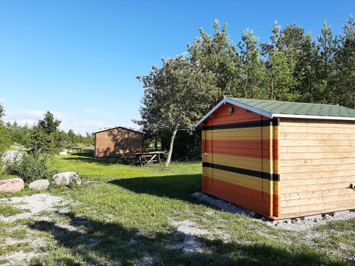 a colorful shed sitting in the grass in a field at Kadakasuitsu Loodustalu in Saareküla