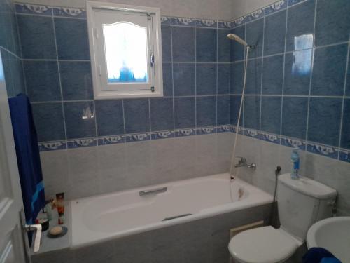 a bathroom with a tub and a toilet and a sink at Villa Chaâbane in Djerba