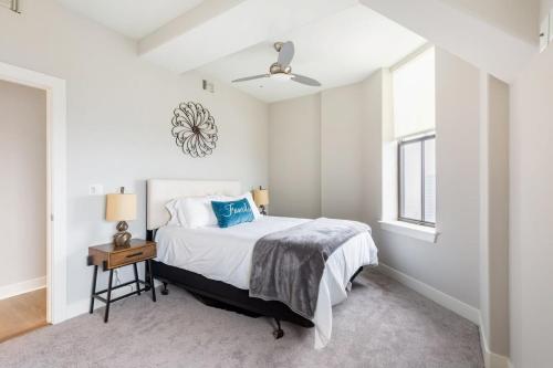 a white bedroom with a bed and a window at 2B 2BA Distinguished Apartment Rooftop Pool & Gym in Baltimore