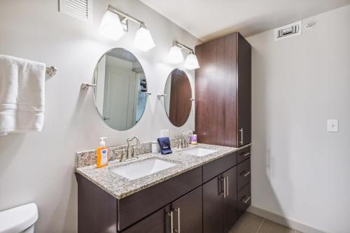 Baño con 2 lavabos y espejo en 2BR Luxury Apartment Rooftop Pool & Gym en Baltimore