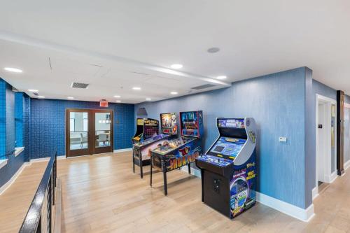 a room with four video game machines in it at 2B 2BA Distinguished Apartment Rooftop Pool & Gym in Baltimore