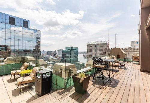 a balcony with a table and chairs on a building at 2B 2BA Distinguished Apartment Rooftop Pool & Gym in Baltimore