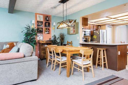 uma cozinha e sala de jantar com uma mesa de madeira e cadeiras em Alaska Hog House: Cozy & Spacious home Anchorage em Anchorage