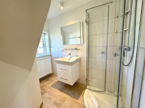 a bathroom with a shower and a sink and a toilet at Westerhus Nieblum in Nieblum