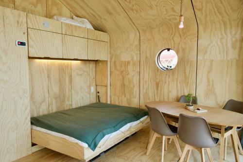 - une chambre avec un lit, une table et des chaises dans l'établissement Wikkelboats at Floating Rotterdam Rijnhaven, à Rotterdam