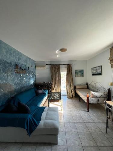 een woonkamer met een blauwe bank en een tafel bij Shells_Haven in Skála Néon Kydonión